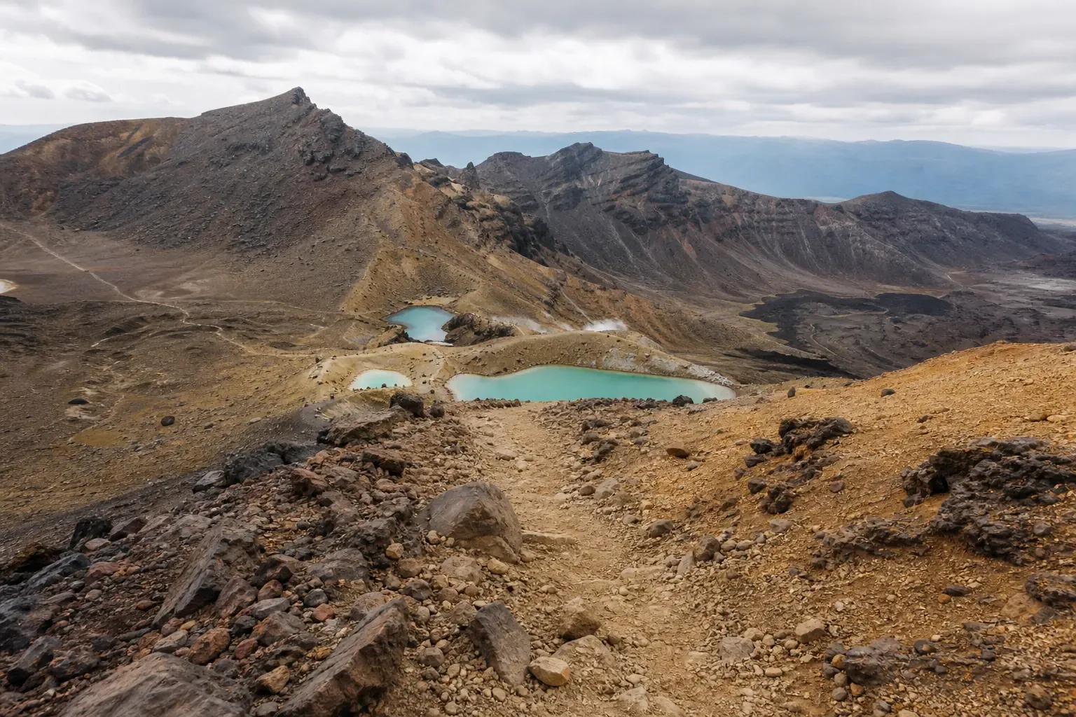 Wanderer auf einem Steig durch die Vulkanlandschaft des Tongariro Alpine Crossing in Neuseeland